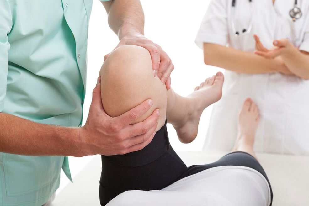 Doctor checks knee for joint pain