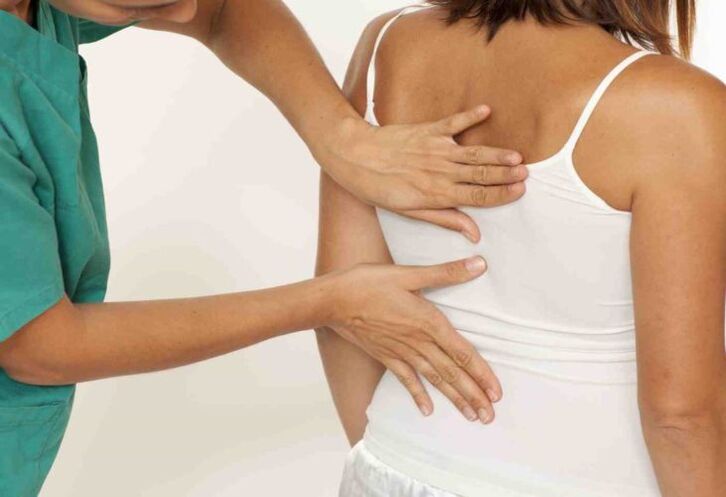 Doctor examining back with shoulder blade pain
